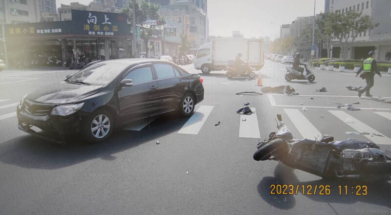 轎車與偉士牌機車路口碰撞，現場零件散落一地。（民眾提供）